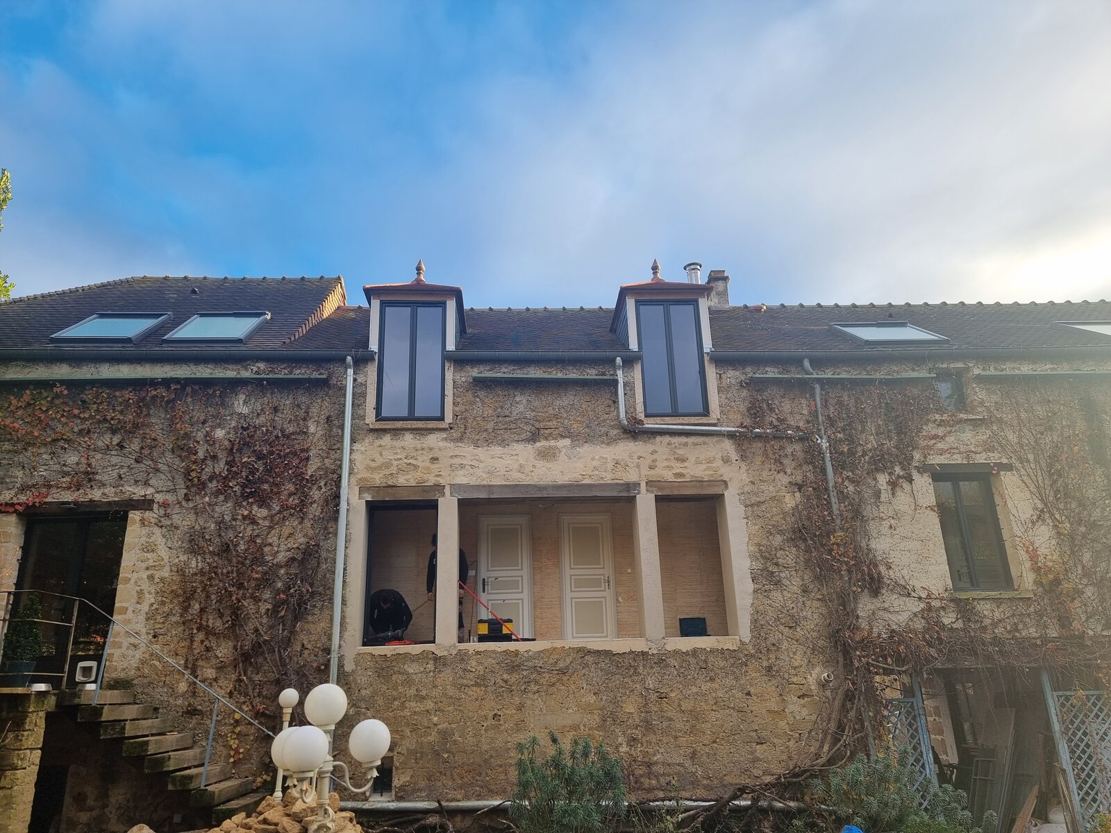 Façade en pierre rénovée avec nouvelles fenêtres